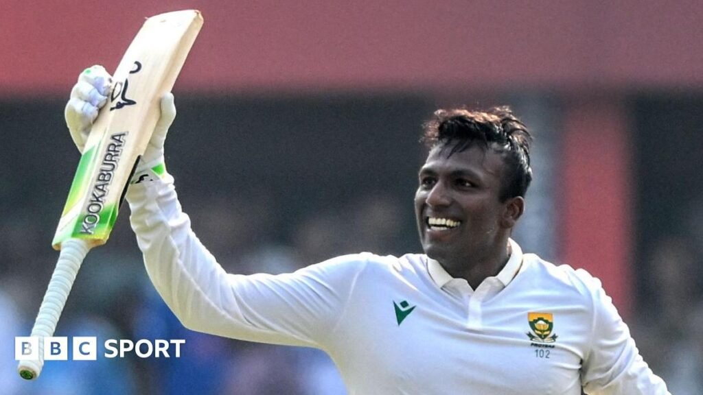 Senuran Muthusamy raises his bat after scoring a century for South Africa