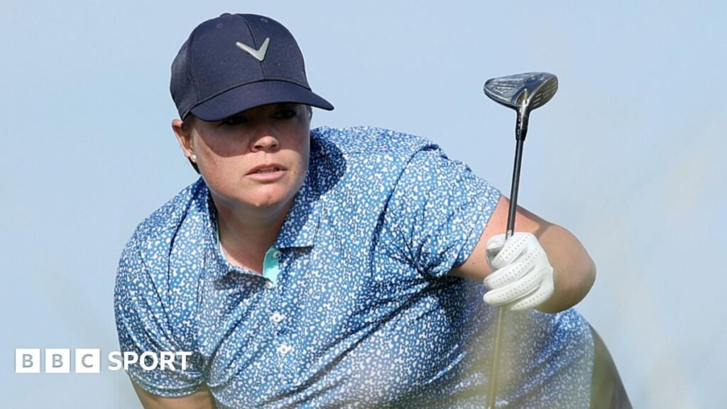 Lydia Hall eyes up her line with golf club in hand