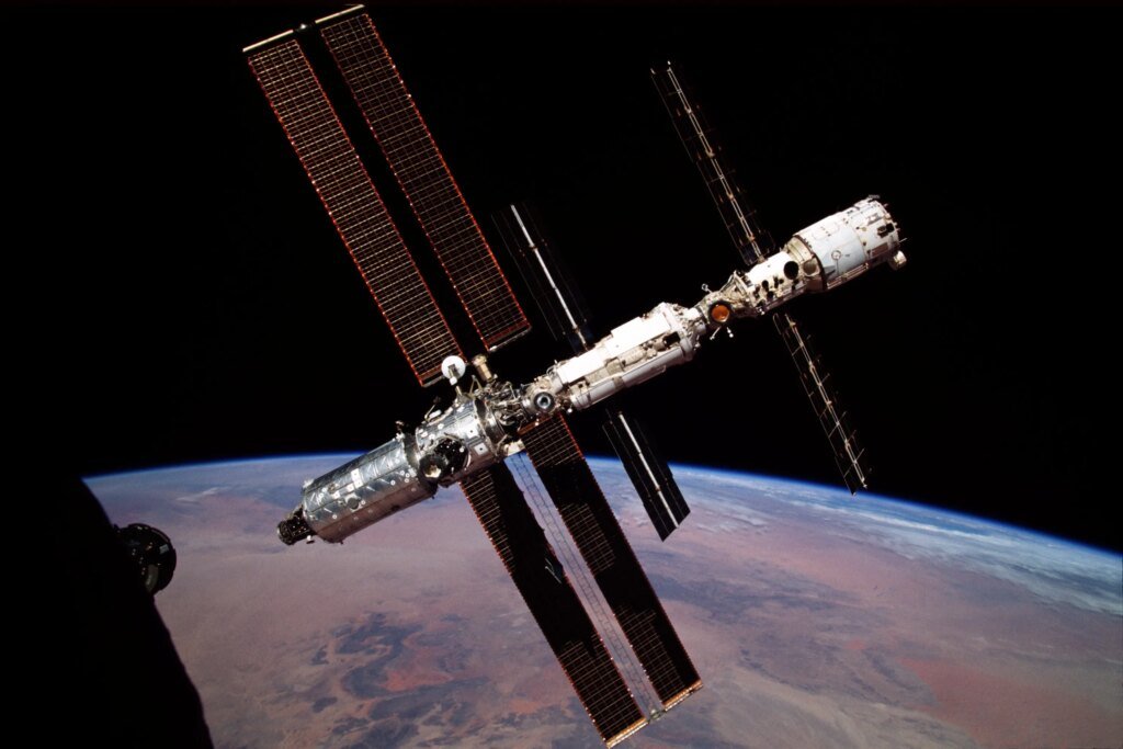 The International Space Station, backdropped against the darkness of space and Earth at its horizon, was photographed by the Expedition 1 crew in 2000, during a fly around aboard a Soyuz capsule.